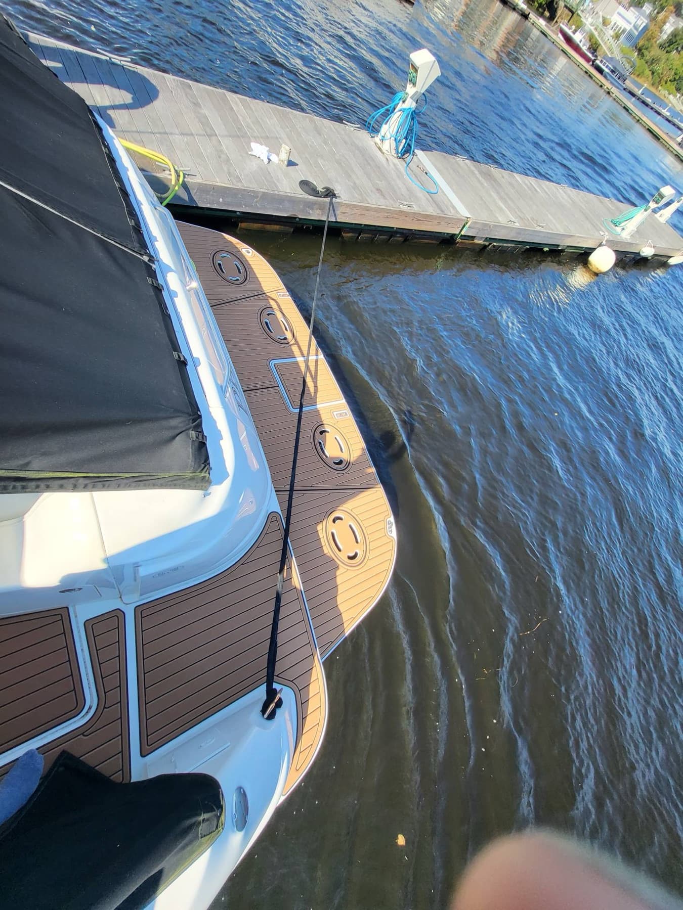 Finished synthetic teak decking on the swim platform, boat alongside the dock.