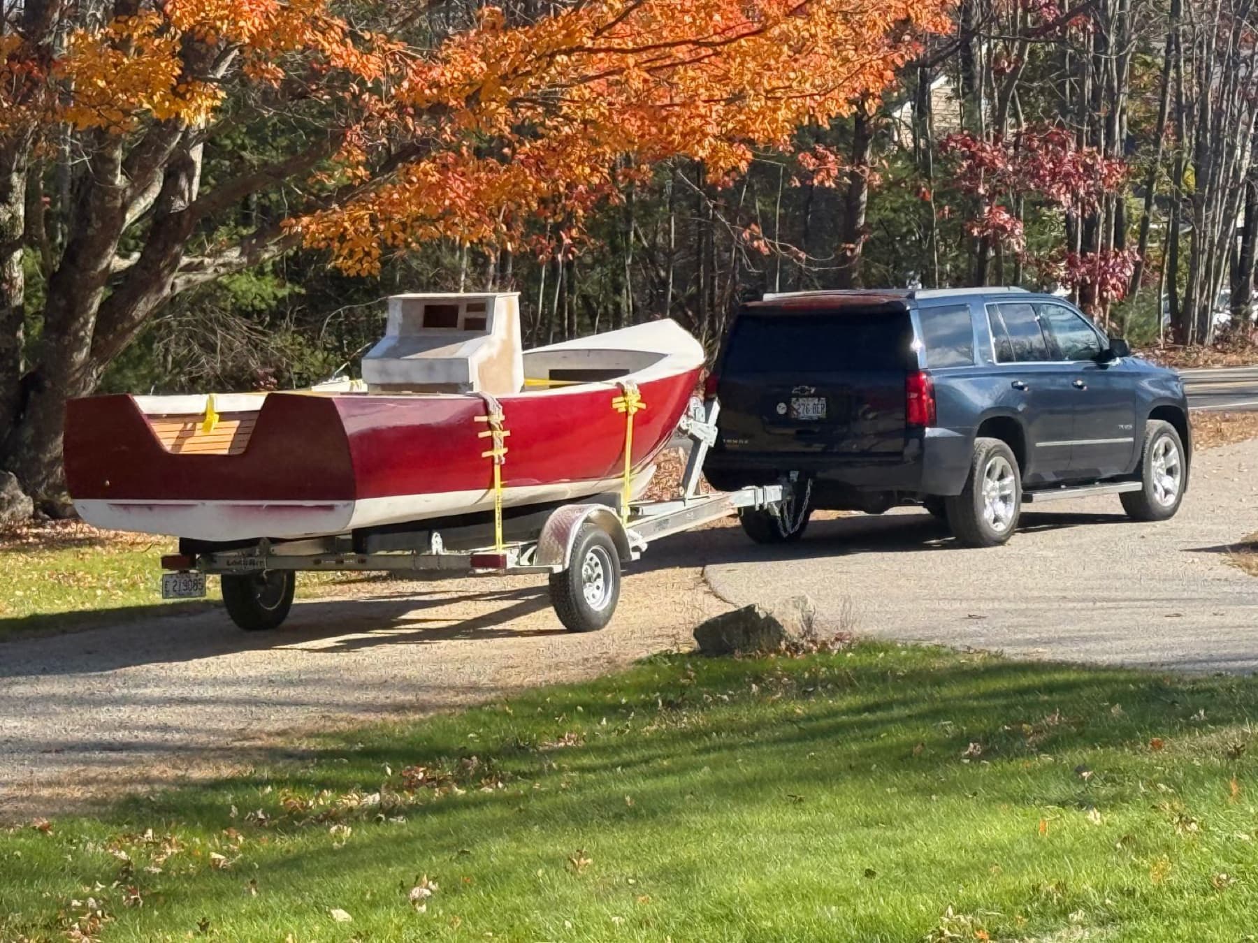 The finished red hull under tow on its trailer.